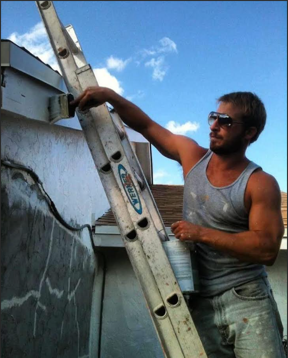 J2 contractor on a ladder working on a residential roof